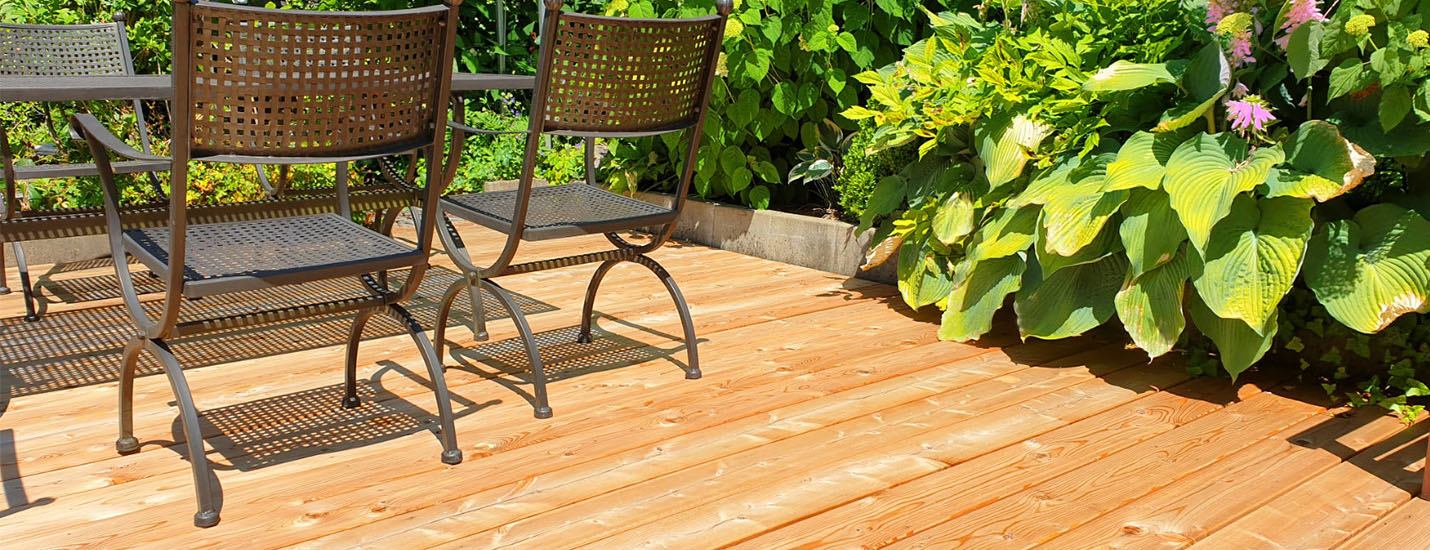Holzterasse mit Gartenstühlen und Pflanzen